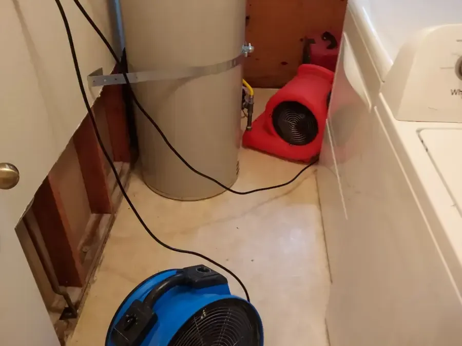 Drying equipment beside laundry appliances and an opened wall
